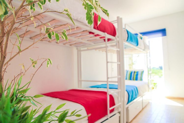 A bright, airy dorm room at the AltaVista Surf Lodge has direct access onto the pool