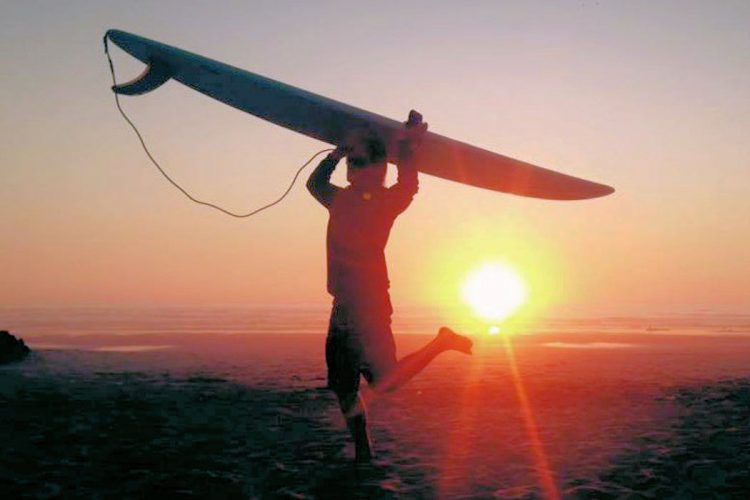 A surfer heading home after a day on the waves in Luz