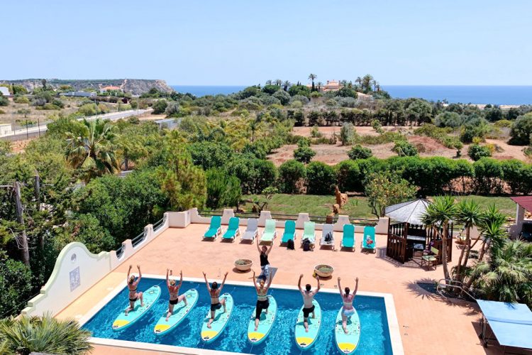 Yoga guests taking a SUP Yoga class in the swimming pool