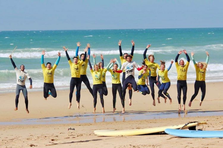 Algarve surfers jumping for joy at the beach surf camp