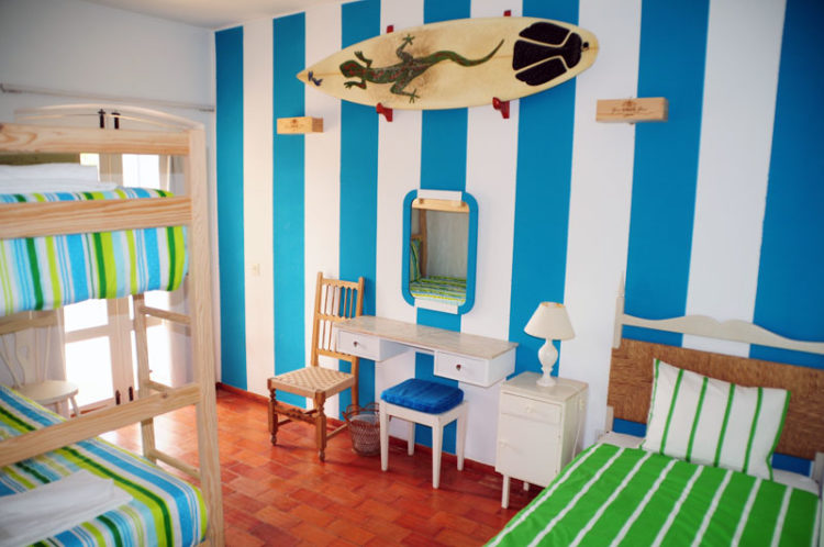 The striped blue and white dormitory room at the j'hola surf camp offers a positive vibe