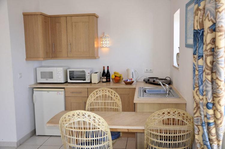 The kitchenette offers a fridge, microwave, hob, kettle and sink with fours chairs and a table