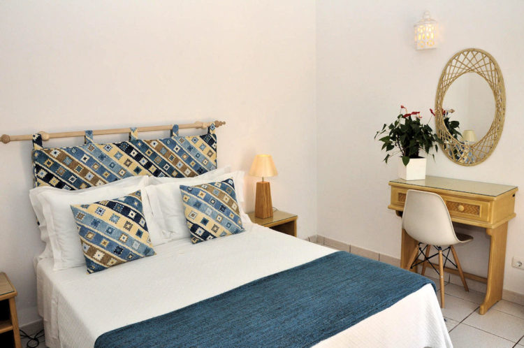 The bedroom at Ocean Villas Luz is spacious, comfortable and clean and has a mirror, table and chair