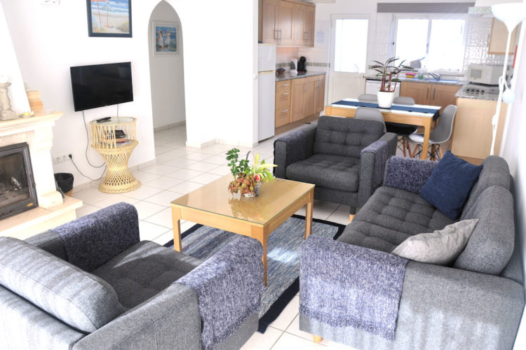 The two bedroom villas at Ocean Villas Luz have three large chairs in the lounge and lead to the open planned kitchen